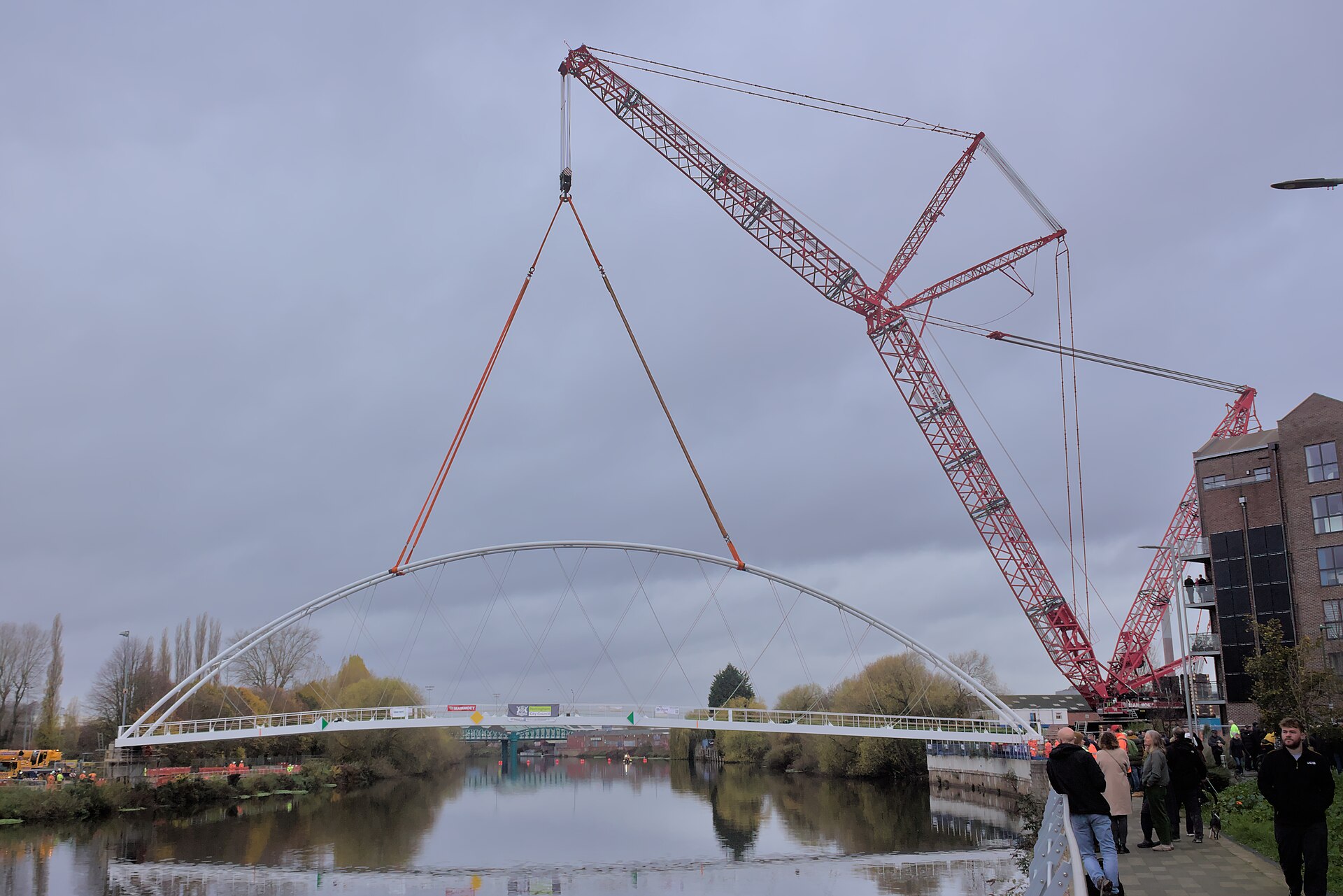 Crane lifting a pedestrian bridge span into place